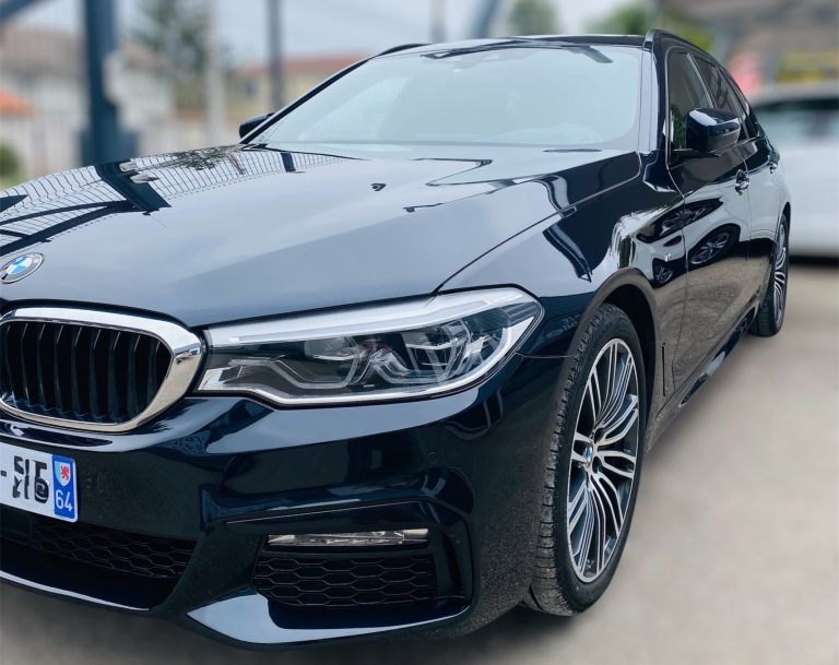 Berline BMW noire, vue de près, élégante avec des jantes sportives.